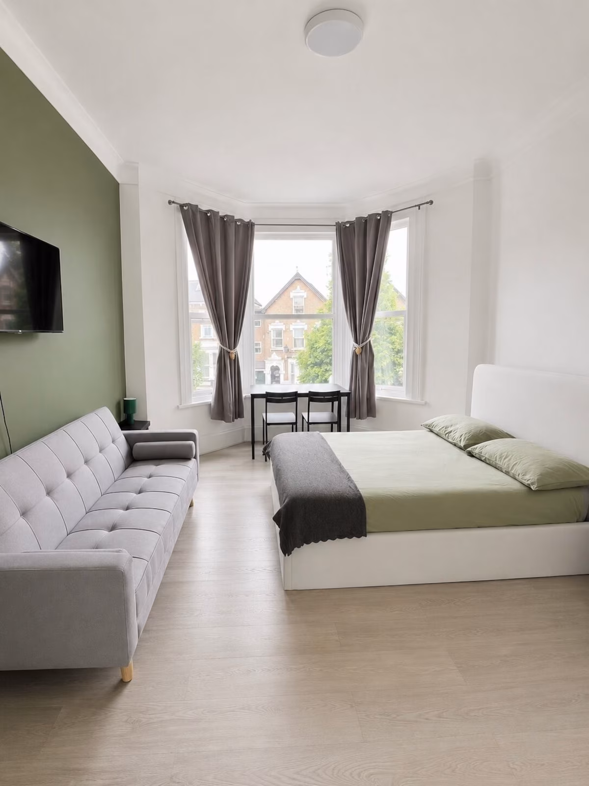 Bright studio interior with dining table, bed and daylight