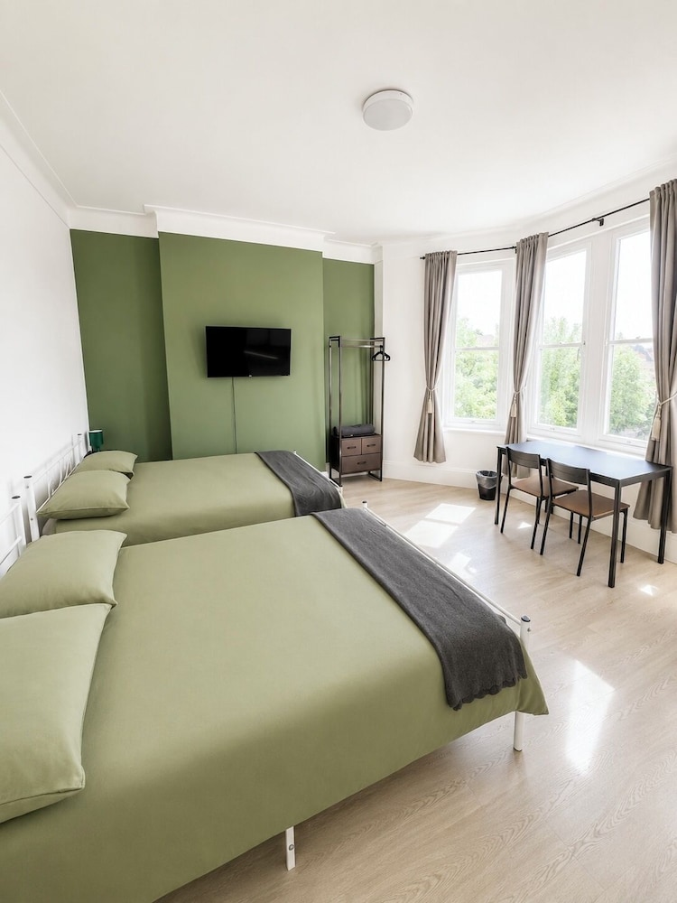 Sunlit self-contained studio at KW Studios with a bed, table and large window